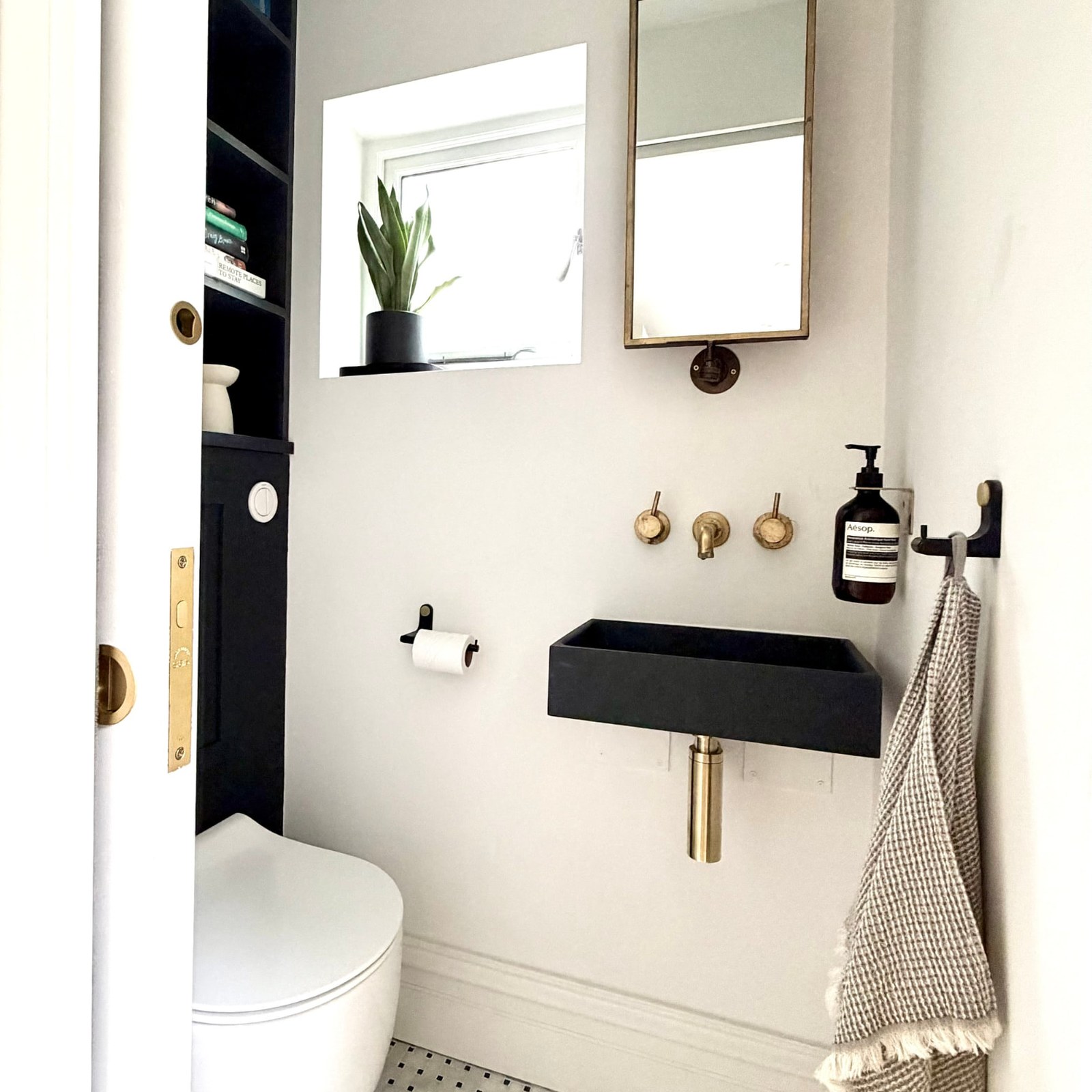 Kennington House cloakroom with black basin and brass taps